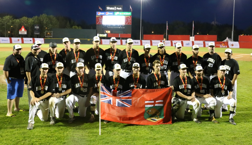 On the left, Faron Asham stands proudly beside his team as they celebrate their hard earned silver medal.